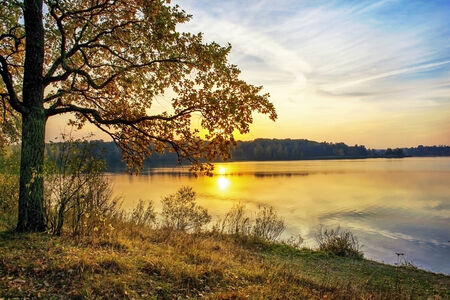 Красивый закат на озере с облаками и отражениями на воде ...