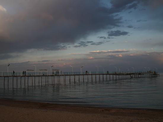 Пирс на берегу моря. Солнце и вода. Берег Черного моря в ...