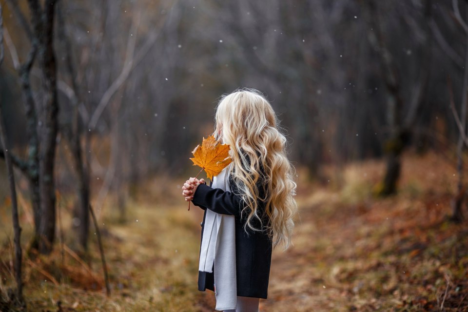 From behind a beautiful young woman with long blonde hair ...